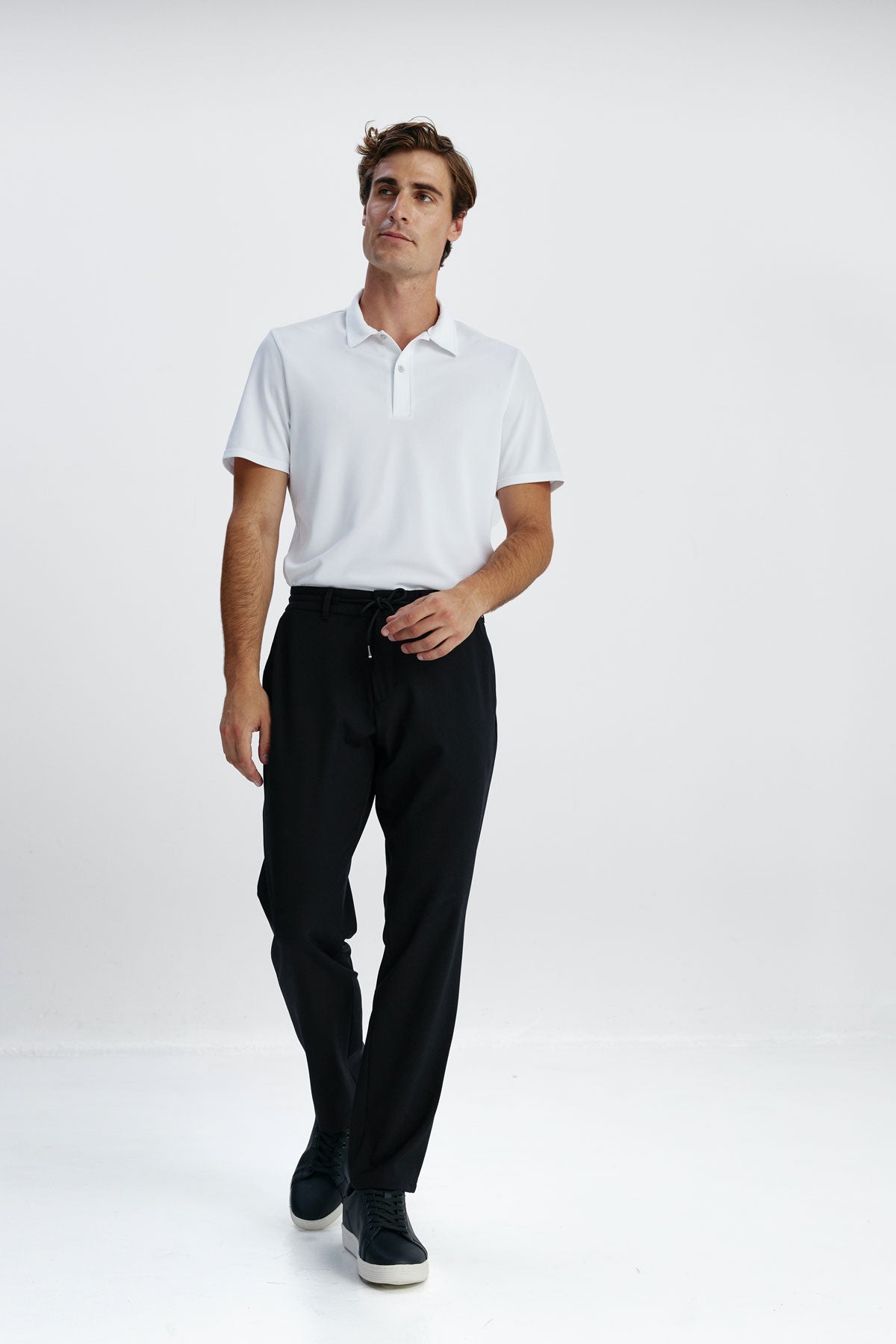Joggers smart fit color negro con diseño formal, cintura elástica y ajustable, tejido transpirable y resistente, ideales para viajar con estilo y comodidad. Foto cuerpo entero.
