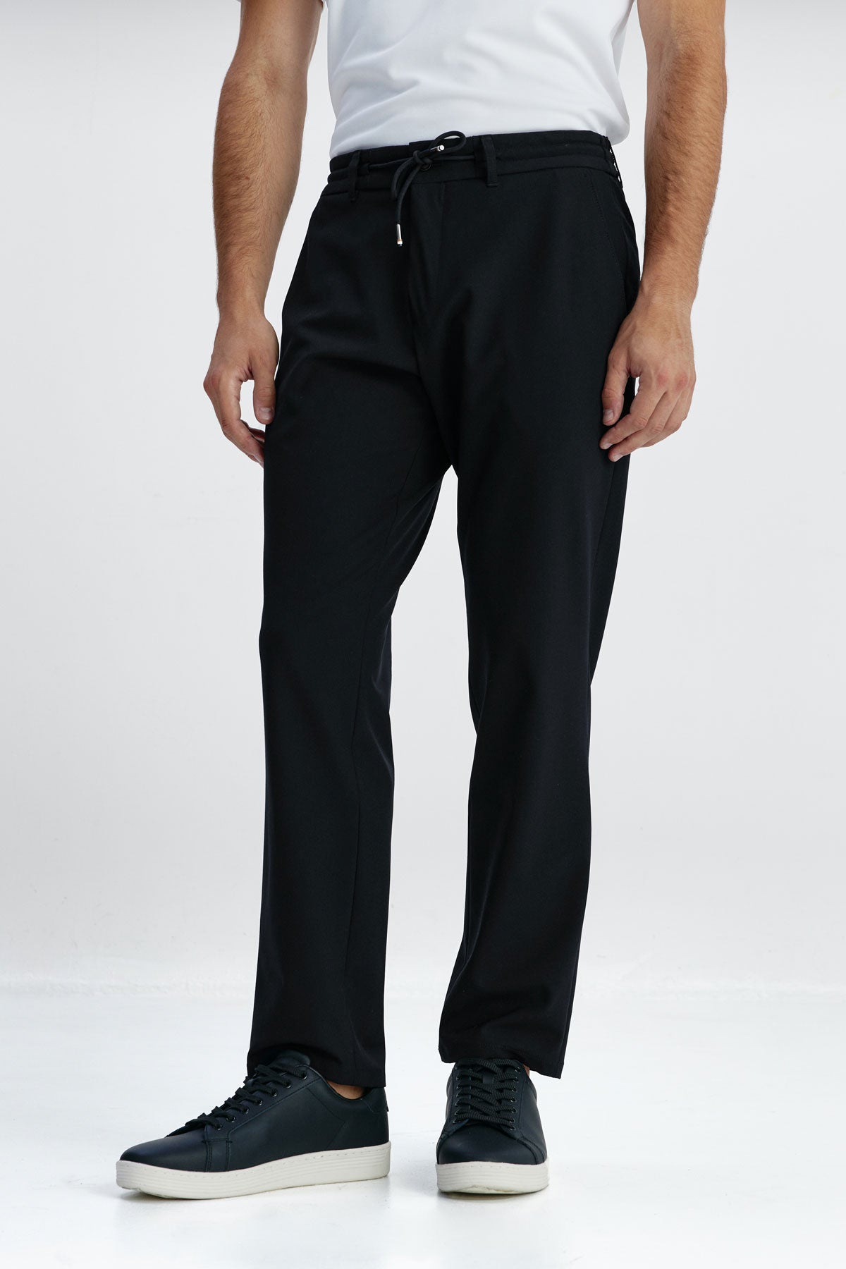 Joggers smart fit color negro con diseño formal, cintura elástica y ajustable, tejido transpirable y resistente, ideales para viajar con estilo y comodidad. Foto de frente.
